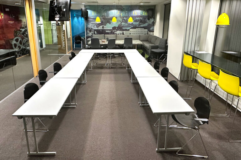 Moderne møterom med hvite bord og gule stoler.