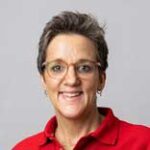 Smilende person med briller og rød skjorte